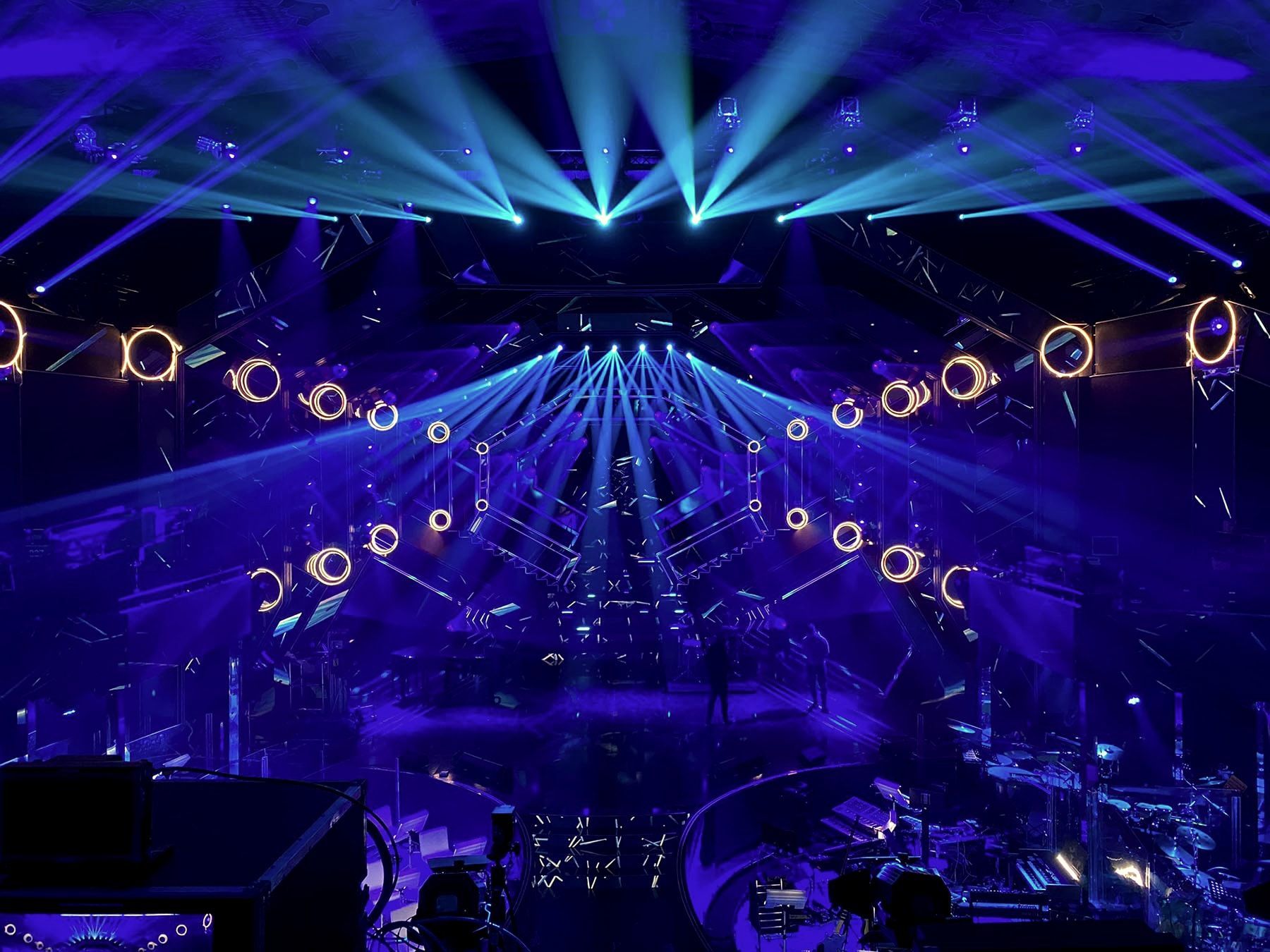 Il palco del Teatro Ariston durante le prove del Festival di Sanremo 2021, con fasci blu e anelli luminosi.