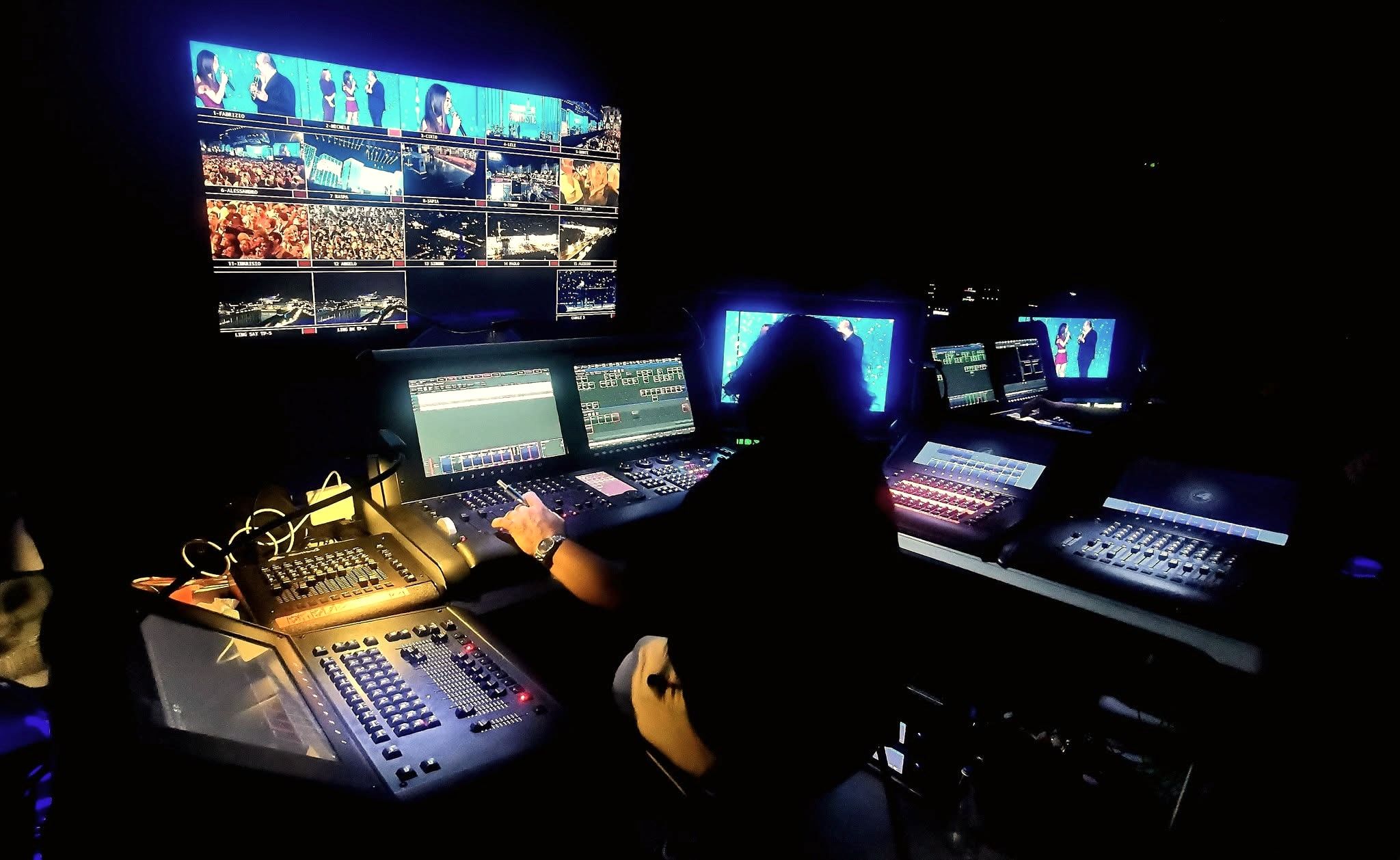 La regia della diretta da Torino: un tecnico di spalle davanti a mixer e monitor.
